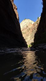 Scenic view of river by mountains against clear sky