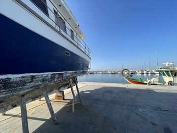 Sailboats moored at harbor against sky