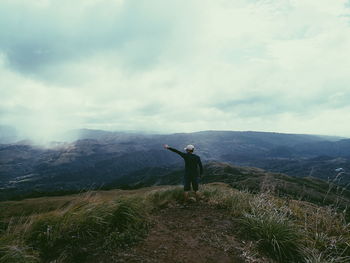 Man standing on mountain against sky