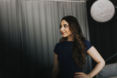 Portrait of woman standing against wall