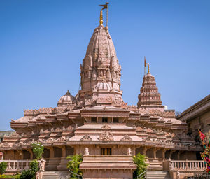 Nice carvings on goddess ekveera temple with flag on clear blue sky background. 