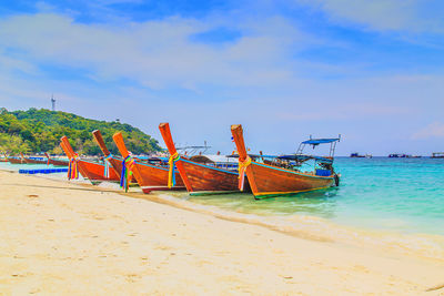 Fishing boat on beach against sky