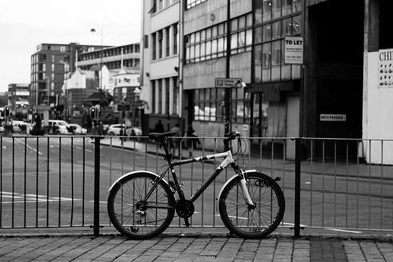 bicycle, building exterior, architecture, transportation, built structure, mode of transport, land vehicle, stationary, parking, parked, city, street, building, outdoors, side view, day, residential structure, sidewalk, railing, window