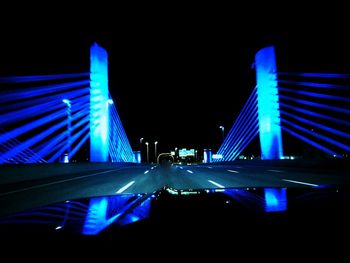 Illuminated bridge in city at night