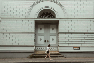 Rear view of man standing against closed door of building