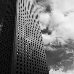 Low angle view of modern building against cloudy sky