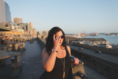 Young woman looking at sea in city