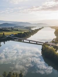 Scenic view of river by mountains against sky