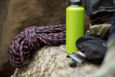 Close-up of water bottle with safety harness on rock