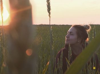 Close-up of young woman on field against sky