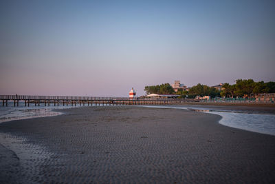 Scenic view of beach against clear sky during sunset