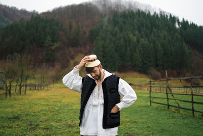 Young man wearing hat standing on field