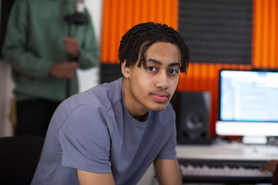 Side view of boy with dreads sitting in recording studio