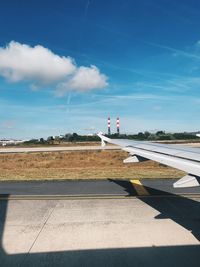 Through the window of the airplane, view on the wing, the tarmac and horizon, ready for departure