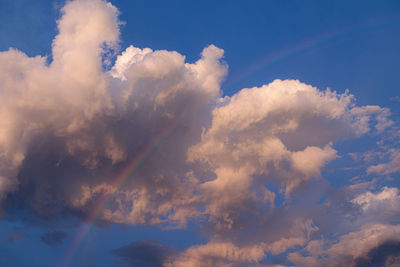 Clouds with a rainbow on a beautiful blue day
