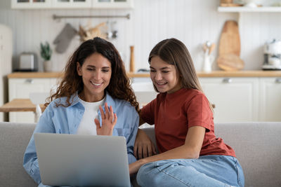 Friends using laptop at home