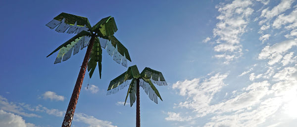 Low angle view of coconut palm tree against blue sky