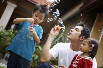 Close-up of family blowing bubble at park