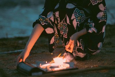 Low section of woman with high angle view of bonfire