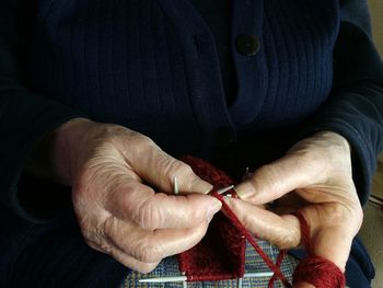 Midsection of person knitting wool