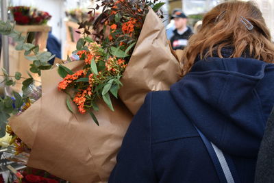 Rear view of man and woman standing by plants