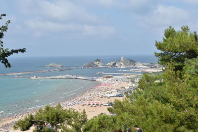 High angle view of city by sea against sky