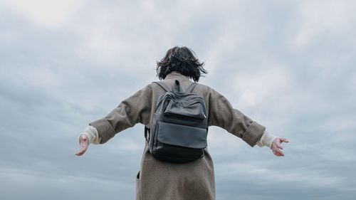 Midsection of man with woman standing against sky