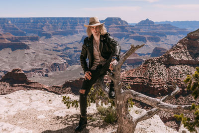 Man standing on rock against mountain range