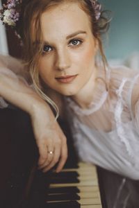 Portrait of beautiful woman leaning on piano at home
