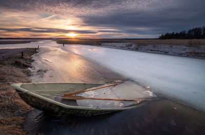 Scenic view of frozen lake against sky during sunset