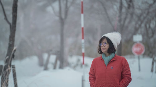 Portrait of young woman standing on snow