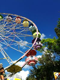 Low angle view of ferris wheel against clear blue sky