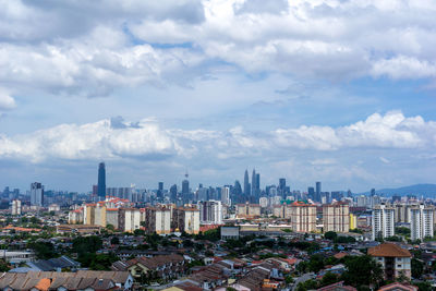 View of cityscape against cloudy sky