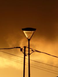 Low angle view of street light against orange sky