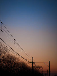 Low angle view of power lines against clear sky