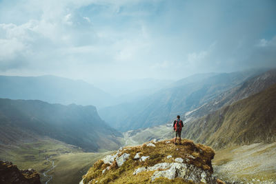 Man looking at mountains against sky