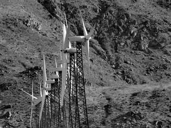 Low angle view of windmills against mountain