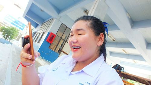 Portrait of smiling young woman holding umbrella