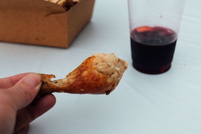 Close-up of hand holding grilled chicken