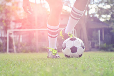 Low section of child playing soccer on field