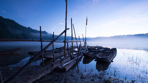 Boats moored in calm lake