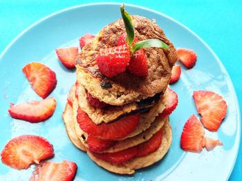 High angle view of pancakes with strawberries in plate at table