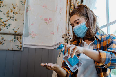 A young woman cleans her hands with alcohol-based hand sanitiser.