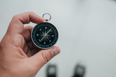 Cropped hand of person holding navigational compass