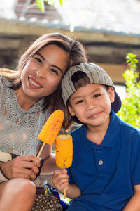 Portrait of mother and son having corn