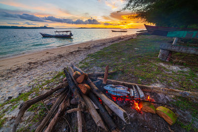 Wooden log on beach against sky