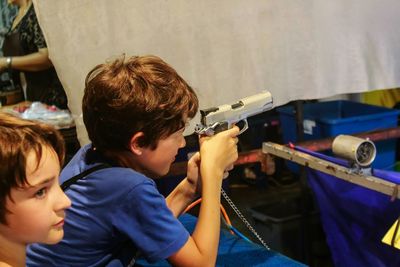 Side view of boy playing with toy gun