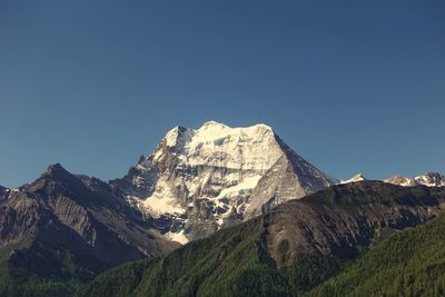 Scenic view of snowcapped mountains against clear blue sky