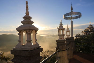 Built structures on railing against sky during sunset