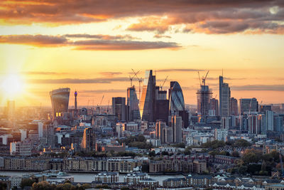 High angle view of cityscape against cloudy sky during sunset